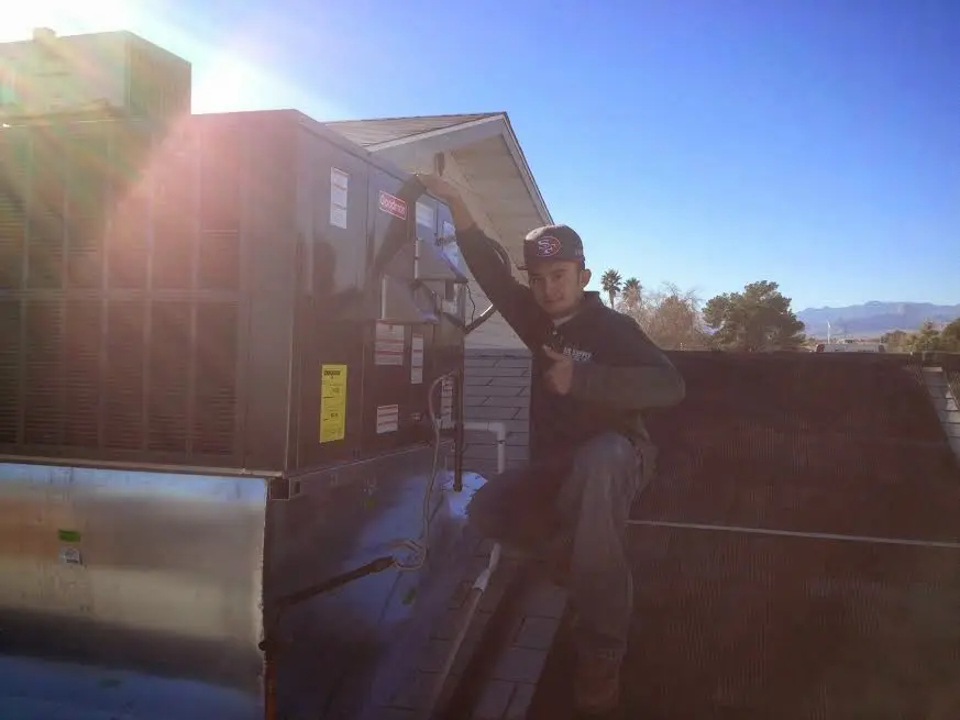 HVAC technician performing Air Duct Cleaning on a rooftop unit in Beaufort