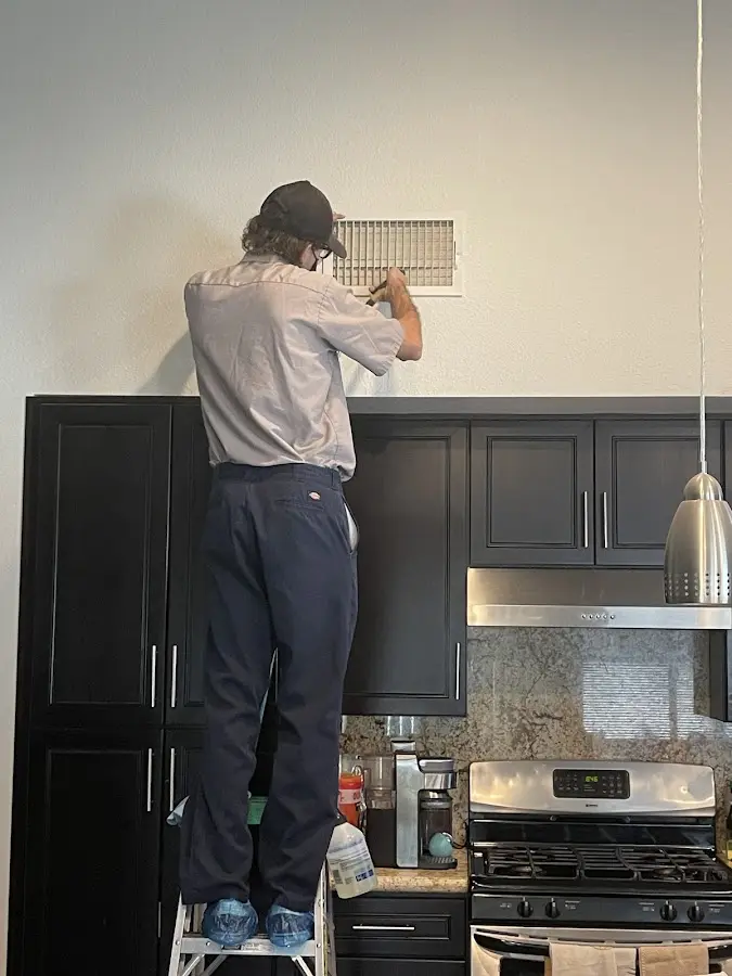Technician inspecting an air vent during HVAC service in Beaufort